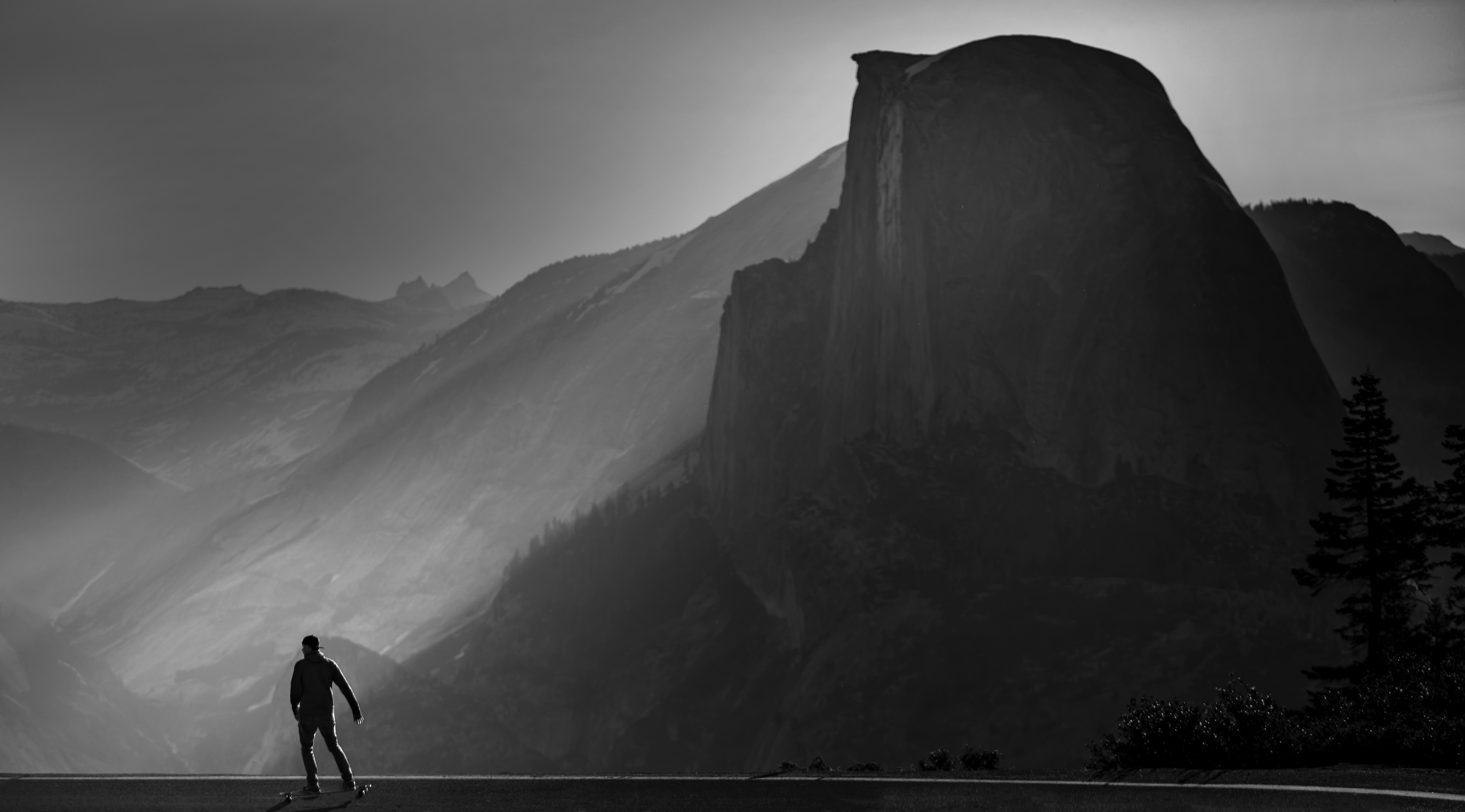 grayscale photo of person walking on mountain